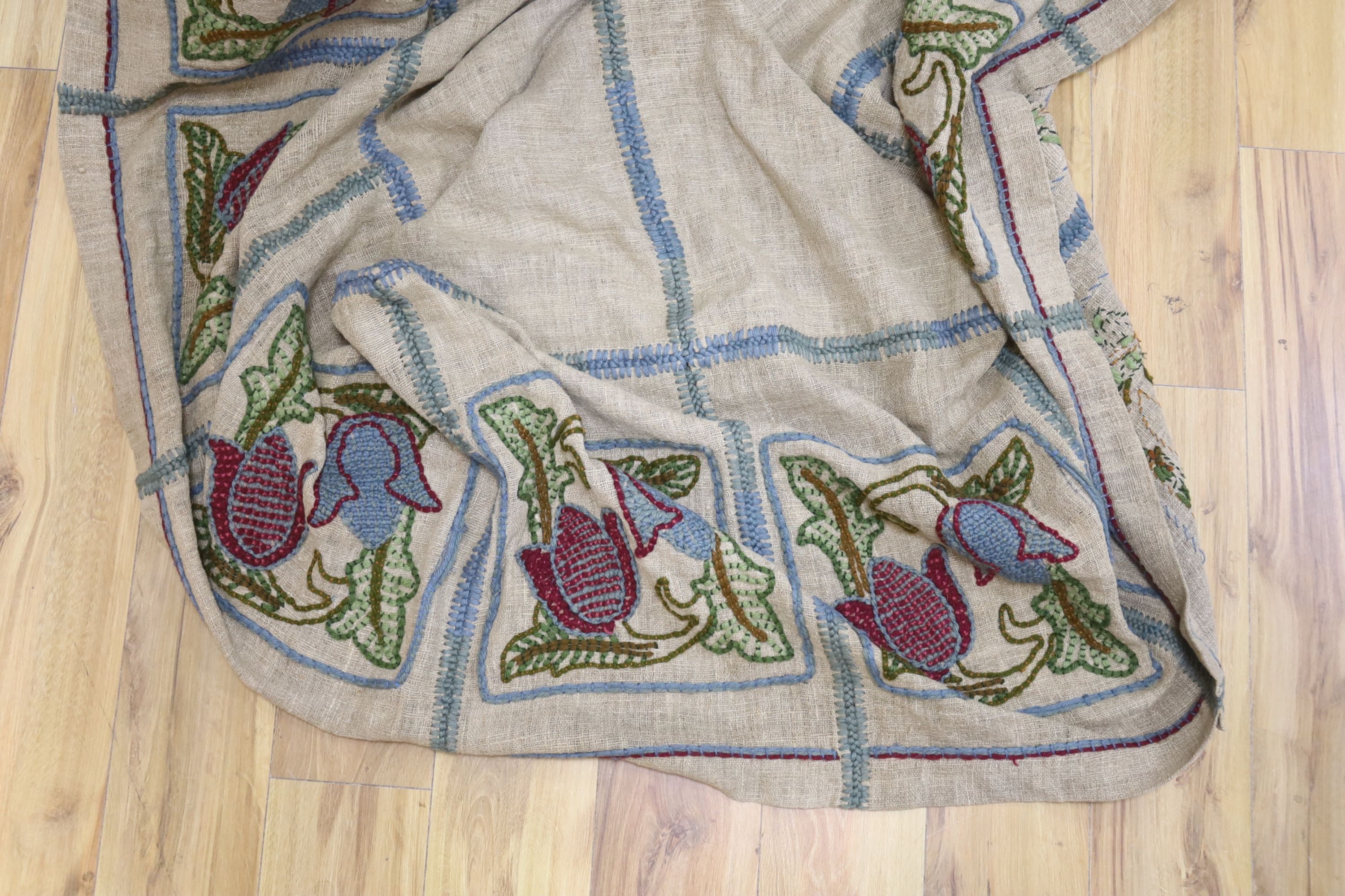 An Arts and Crafts embroidered on hessian table cover with fitted sides, decorated crewelwork embroidery